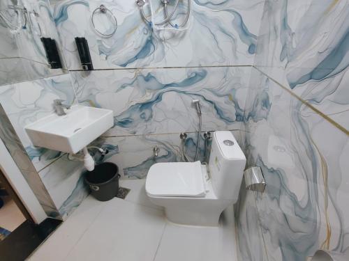 a bathroom with a white toilet and a sink at Hotel Orchha Heritage in Orchha