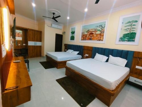 a hotel room with two beds and a desk at Hotel Orchha Heritage in Orchha