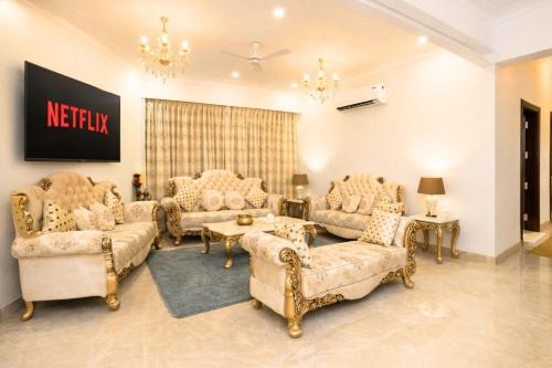 a living room with couches and a chandelier at Palm 34 in Jaipur