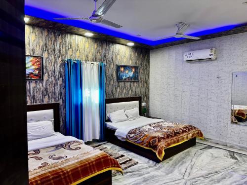 two beds in a room with blue lighting at Taj Castle Homestay in Agra