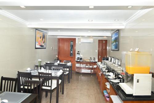 une salle à manger avec des tables et des chaises ainsi qu'un restaurant dans l'établissement Hotel Bond, à Yangon