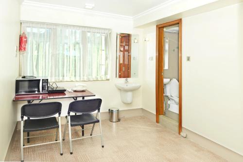 a room with a desk with two chairs and a microwave at Hotel Bond in Yangon