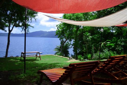 a hammock and a bench next to a lake at Laguna Beach Club in La Laguna