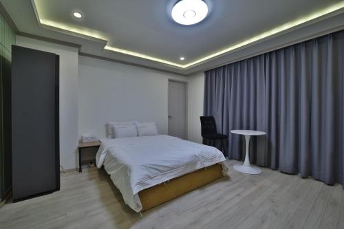 a bedroom with a bed and a table in it at 위드유 호텔 광주역 in Kwangju-yŏk