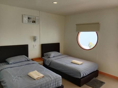 a bedroom with two beds and a window at มานอนนี่ รีสอร์ท in Ban Wang Thong