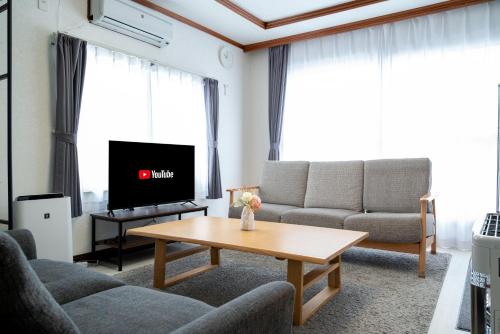 a living room with a couch and a table at Furano Ski House in Furano