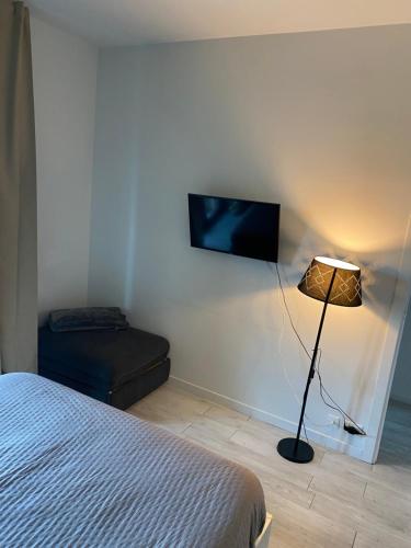 a bedroom with a bed and a lamp and a flat screen tv at Appartamento 47 in Novara