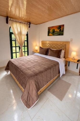 a bedroom with a large bed and a window at La Casita de Carpintero in Cucunubá