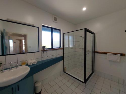 a bathroom with a shower and a sink and a mirror at Blue Oasis in Esperance