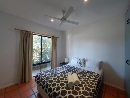 a bedroom with a bed with a ceiling fan and a window at Blue Oasis in Esperance