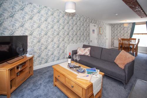 a living room with a couch and a tv at The Crown in Poole