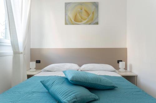 a bed with two blue pillows on top of it at Easy Venice Rooms 1- 2 in Mestre