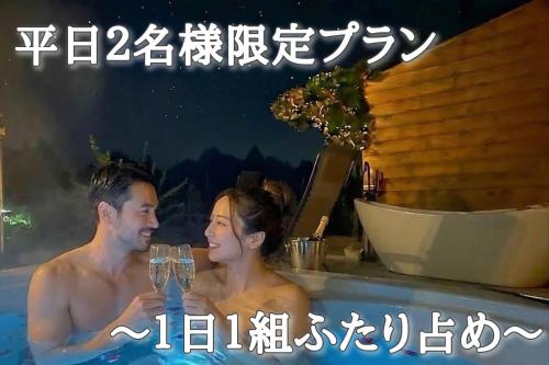 a man and a woman in a swimming pool with a drink at スターハウス in Otsu