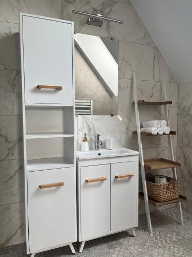 a bathroom with a white cabinet and a sink at Apartamenty nad Przełomem Białki Apartments in a nature reserve Przełom Białki in Nowa Biała