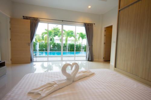 Ein Schwan, der wie ein Herz auf einem Bett aussieht in der Unterkunft Luxury House in Hua Hin in Khao Tao