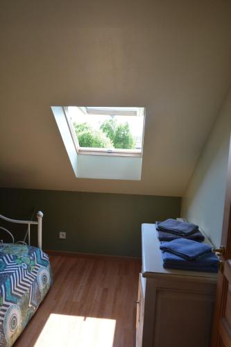 a attic room with a bed and a window at Bienvenu dans le Java chez Pommes & Chevaux in Favières