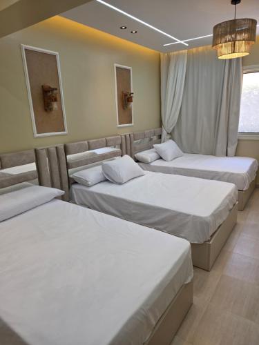 a room with three beds and a window at Adel Apartments at alkarma resorts& aquapark in Hurghada