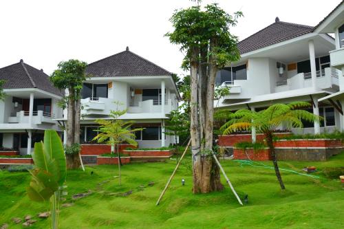 an apartment complex with palm trees in the yard at Samara Resort in Batu