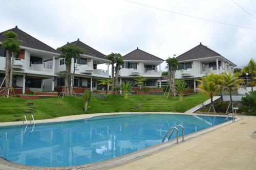 a swimming pool in front of some houses at Samara Resort in Batu