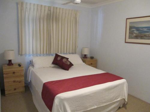 a bedroom with a bed and two dressers and a window at Kalbarri Riverfront Unit in Kalbarri