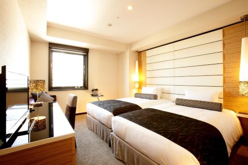 a hotel room with a large bed and a large window at Hotel Trusty Osaka Abeno in Osaka