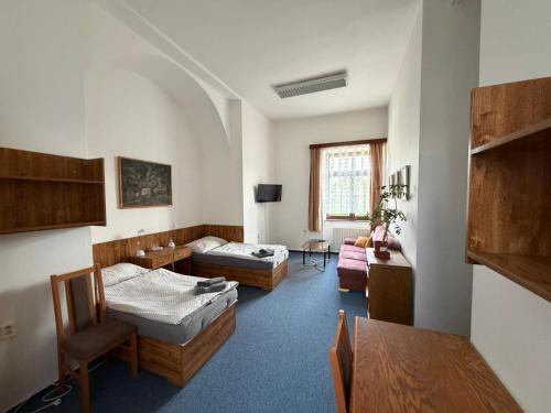 a living room with two beds and a table at Koleje Zámeček in Lednice