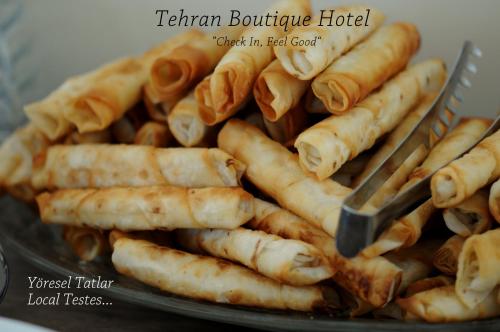 ein Teller mit Essen, dazu eine Zange und Nudeln. in der Unterkunft Tehran Boutique Hotel in Doğubayazıt