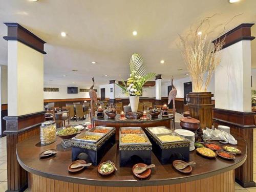 a buffet of food on a table in a restaurant at Grand Whiz Hotel Trawas Mojokerto in Trawas