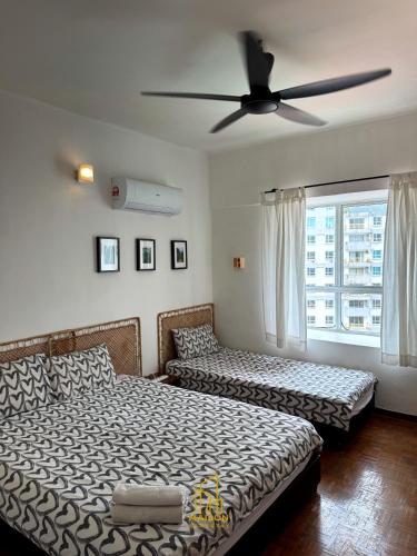 a bedroom with two beds and a ceiling fan at BayView Suites Port Dickson By MAISON in Port Dickson