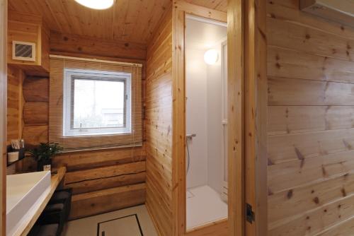 a bathroom with wooden walls and a walk in shower at ヴィラ湖西 最大11名 琵琶湖ビュー165平米の一棟貸切ログハウス BBQハウス完備 広々3LDK ロフト Wi-Fi in Takashima