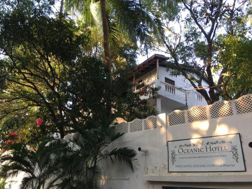 a white building with a sign in front of it at Oceanic - Luxury Boutique Hotel in Palolem