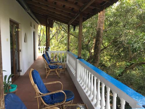 a porch of a house with chairs and a table at Oceanic - Luxury Boutique Hotel in Palolem