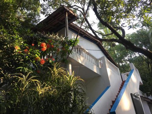 a white house with a balcony with flowers on it at Oceanic - Luxury Boutique Hotel in Palolem