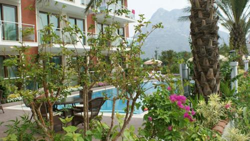 a view of a hotel with a pool and flowers at Palmira Hotel in Adrasan