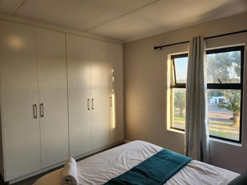 a bedroom with a bed and a window at Manchester Heights in Cape Town