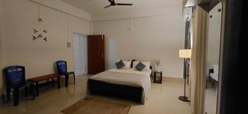 a bedroom with a bed and a ceiling fan at Pipitsnest 2 homes in Tezpur