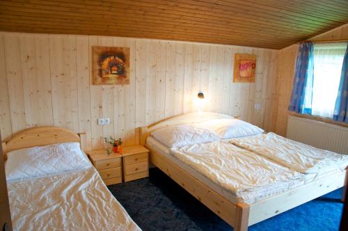 a bedroom with two beds in a room with wooden walls at Grasreithof in Grossarl