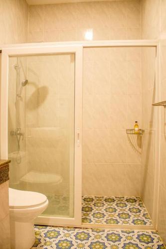 a bathroom with a shower and a toilet at Wilcon Guesthouse Catulayan in San Juan
