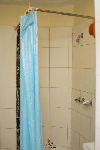 eine Dusche mit blauem Duschvorhang in einem Badezimmer in der Unterkunft Cicada Hotel in Eldoret