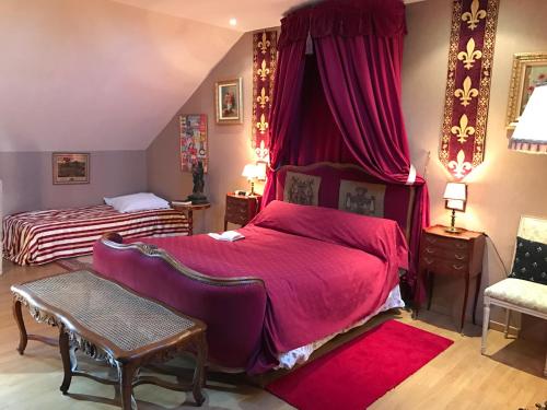 a bedroom with two beds with red sheets at Résidence La Beauceronne in Ouarville