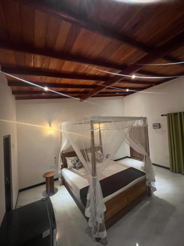 a bedroom with a bed with a canopy at The villa Evans in Pitiduwa