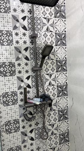 a bathroom with a wall with black and white tiles at Grand studio tout équipé in Ben Mered