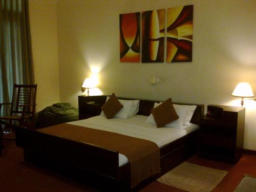 a bedroom with a large bed with two lamps on it at Silvikris Villa in Colombo