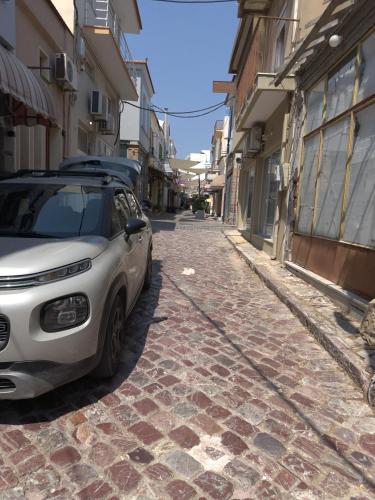 a white car parked on a cobblestone street at Volakis apartments in Chios