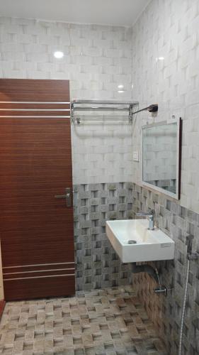 a bathroom with a sink and a wooden door at Hotel Sivani in Kalakkādu
