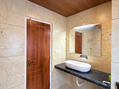 a bathroom with a sink and a mirror at The Trippy Tribe Manali in Manāli