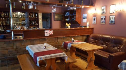 a bar with a leather couch and a table at Valensija in Jūrmala
