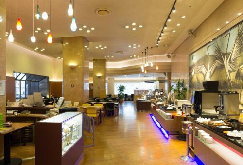 a restaurant with tables and chairs and a cafeteria at New Otani Inn Sapporo in Sapporo