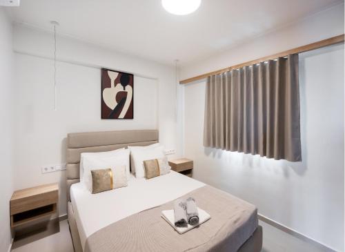 a white bedroom with a bed and a window at Asmira Apartments in Lygia