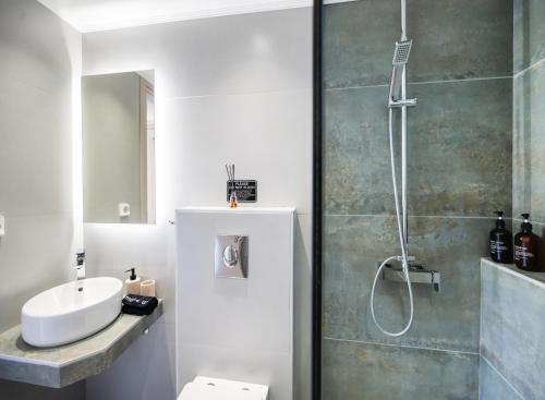 a bathroom with a shower and a toilet and a sink at Asmira Apartments in Lygia